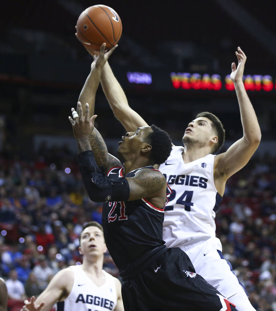Fresno State Bulldogs guard Deshon Taylor (21) goes to the basket against Utah State Aggies guard Diogo Brito (24) during the first half of a semifinal basketball game in the Mountain West men's b ...