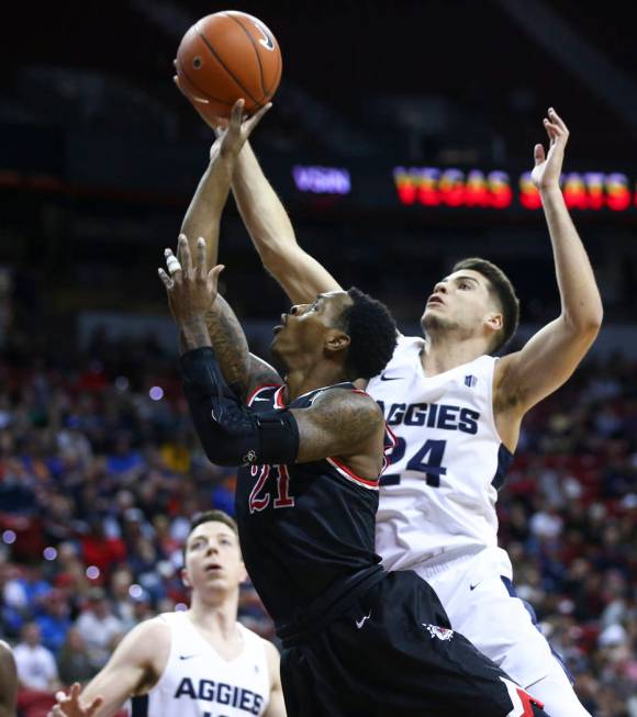 Fresno State Bulldogs guard Deshon Taylor (21) goes to the basket against Utah State Aggies guard Diogo Brito (24) during the first half of a semifinal basketball game in the Mountain West men's b ...