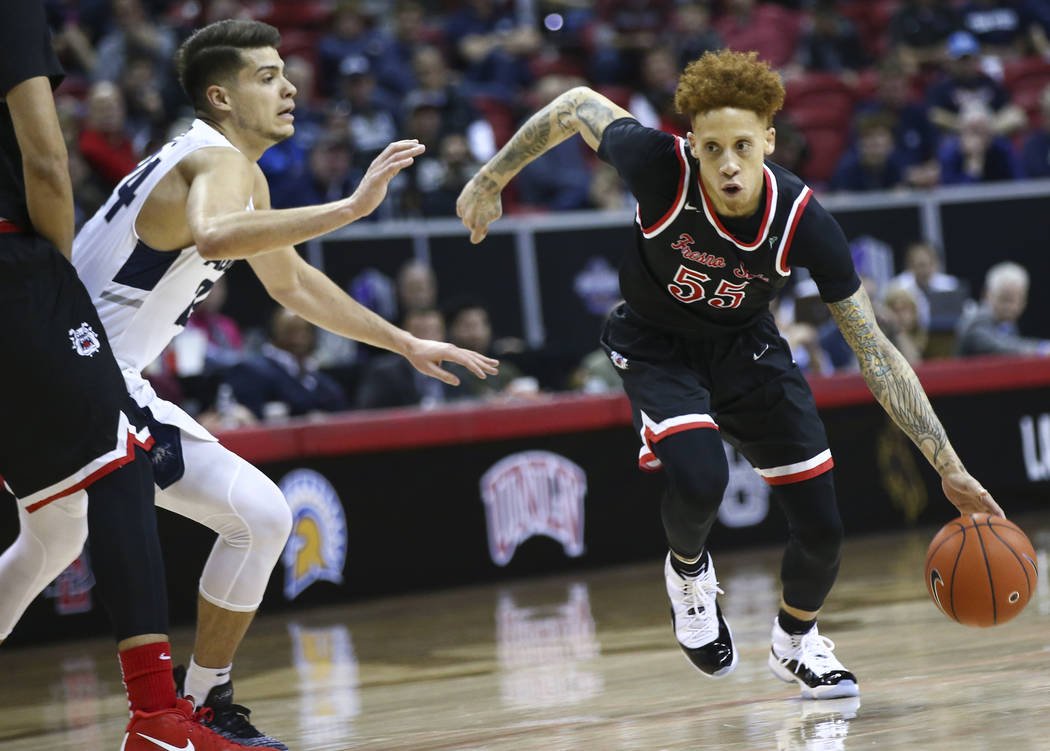 Fresno State Bulldogs guard Noah Blackwell (55) drives past Utah State Aggies guard Diogo Brito during the first half of a semifinal basketball game in the Mountain West men's basketball tournamen ...