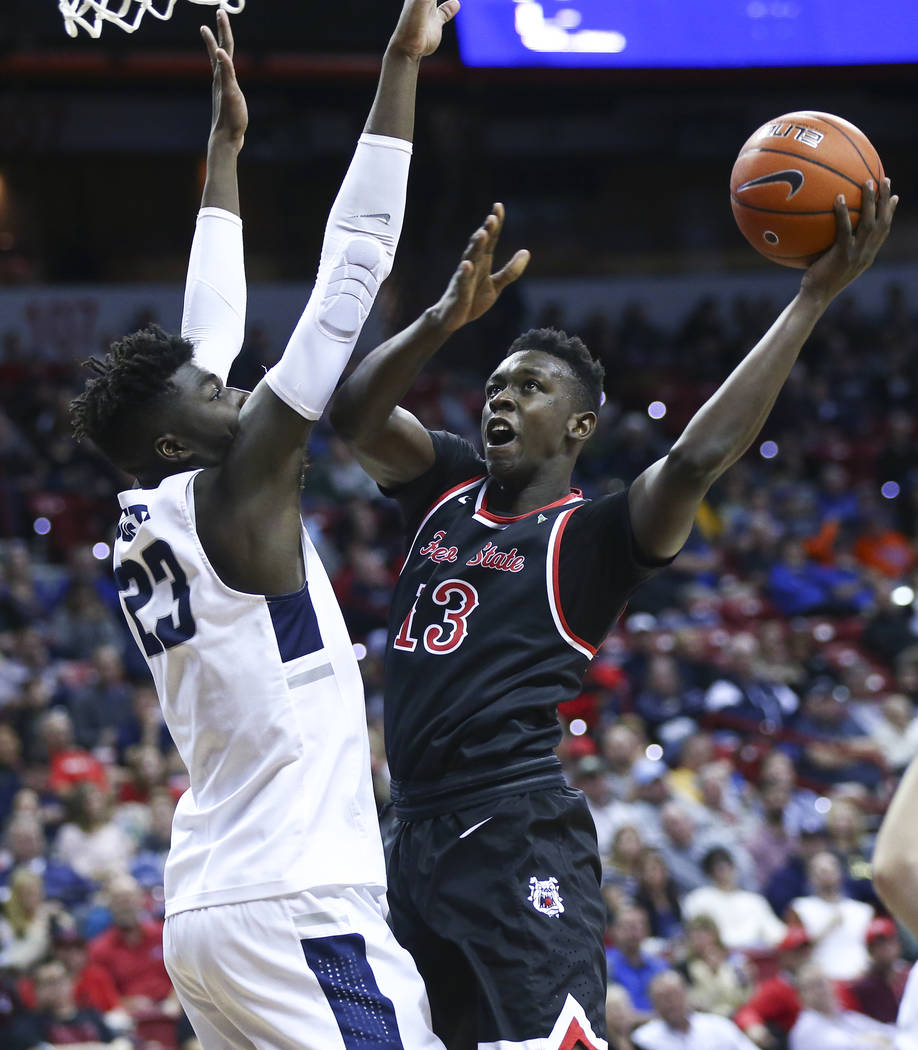 Fresno State Bulldogs guard Aguir Agau (13) goes to the basket againt Utah State Aggies center Neemias Queta (23) during the first half of a semifinal basketball game in the Mountain West men's ba ...