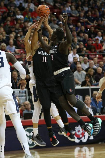 San Diego State Aztecs forward Matt Mitchell (11) leaps a loose ball with forward Aguek Arop (3) against Utah State Aggies in the first half of the Mountain West tournament men's basketball champi ...