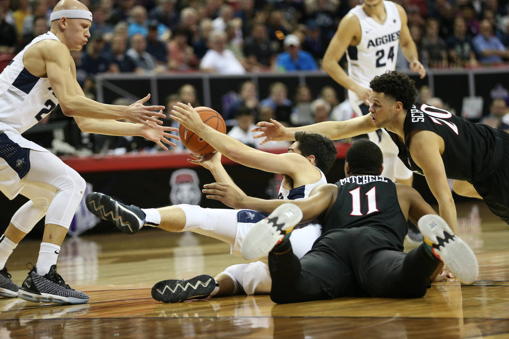 Utah State Aggies guard Abel Porter (15) makes a pass to guard Brock Miller (22) under pressure from San Diego State Aztecs forward Matt Mitchell (11) and guard Jordan Schakel (20) in the first ha ...