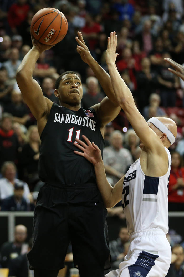 San Diego State Aztecs forward Matt Mitchell (11) shoots the ball under pressure from Utah State Aggies guard Brock Miller (22) in the first half of the Mountain West tournament men's basketball c ...