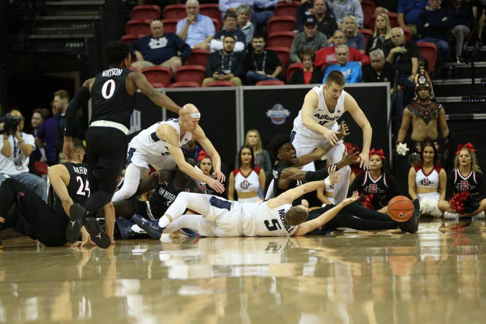 Utah State Aggies and San Diego State Aztecs fight for a loss ball in the second half of the Mountain West tournament men's basketball championship game at the Thomas & Mack Center in Las Vega ...