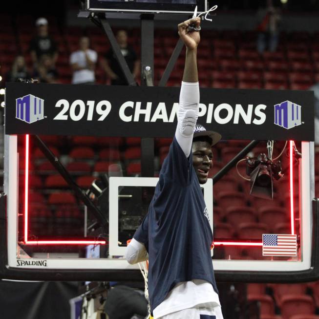 Utah State Aggies center Neemias Queta (23) raises a piece of a net after winning against San Diego State Aztecs in the Mountain West tournament men's basketball championship game at the Thomas &a ...