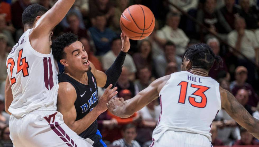 Duke guard Tre Jones (3) gets off a pass between Virginia Tech defenders Kerry Blackshear Jr, (24) and Ahmed Hill (13) during the first half of an NCAA college basketball game in Blacksburg, Va., ...