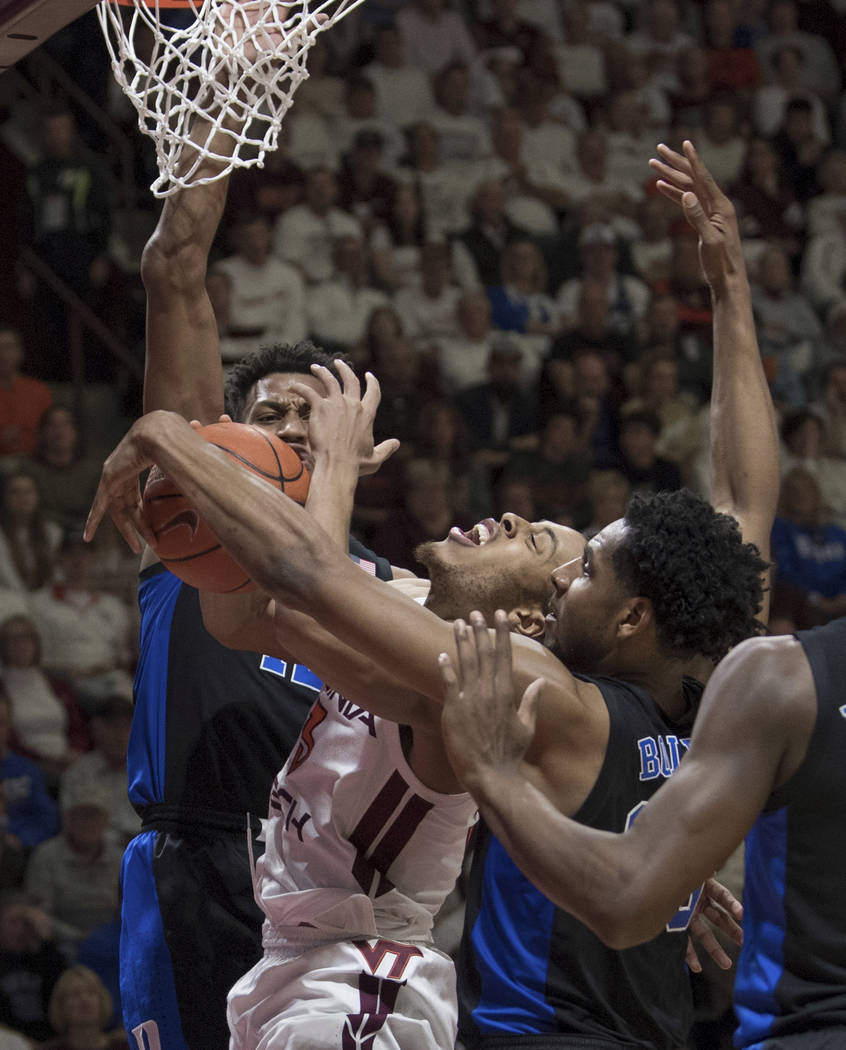 Virginia Tech guard Wabiss Bede (3) is fouled as Duke's Javin DeLaurier, top and Marquis Bolden defend during the second half of an NCAA college basketball game in Blacksburg, Va., Tuesday, Feb. 2 ...
