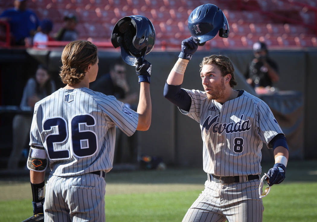 UNR infielder Joshua Zamora (8) lifts his helmet off to outfielder Nick Seamons (26) after hitting the a game-winning home run in the tenth inning during an NCAA baseball game at Earl E. Wilson St ...