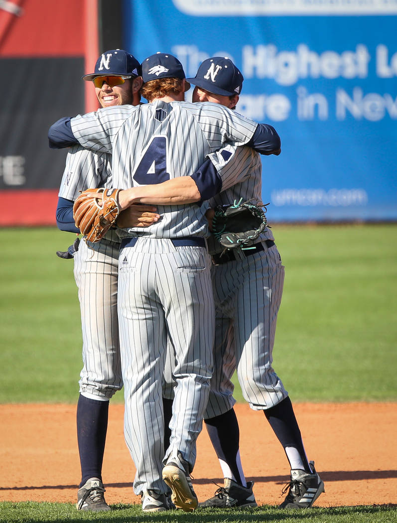 UNR infielder Keaton Smith (4) hugs infielder Wyatt Tilley (7), left, and infielder Tyler Bostti after winning against UNLV during an NCAA baseball game at Earl E. Wilson Stadium in Las Vegas, Sun ...