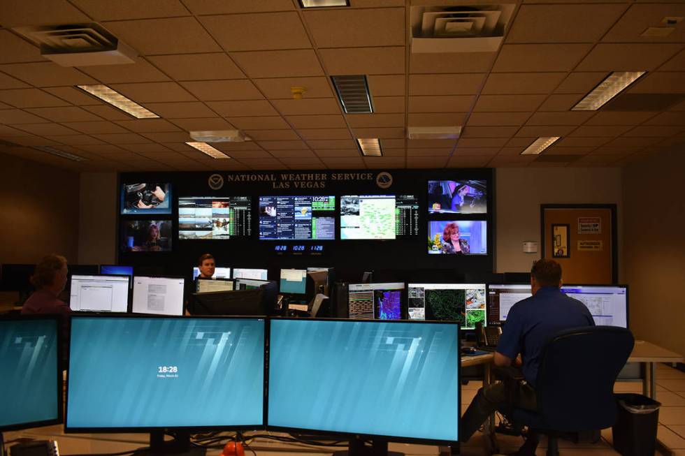 Three meteorologists at their work stations at the Las Vegas National Weather Service office on Dean Martin Drive on Friday, March 1 at 10 a.m. (Rachel Spacek/Las Vegas Review-Journal @Rachel Spacek)