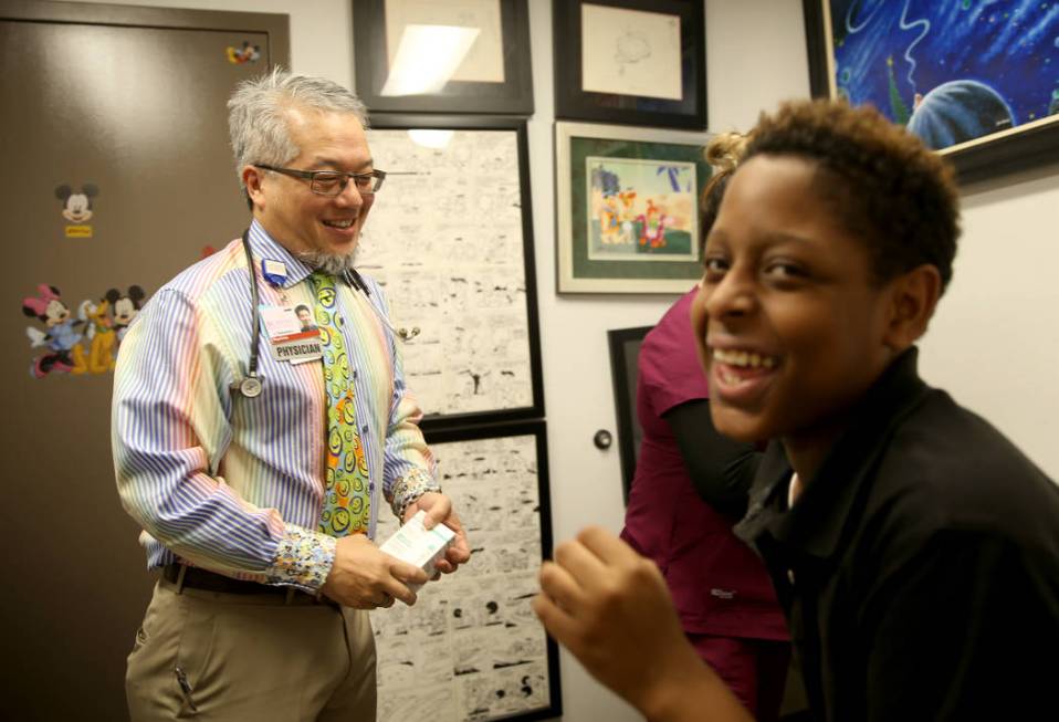 Pulmonologist Dr. Craig Nakamura, director of the Cystic Fibrosis Center of Southern Nevada, makes patient Aarin Shepard, 11, laugh before an examination at his Las Vegas office Thursday, March 7, ...