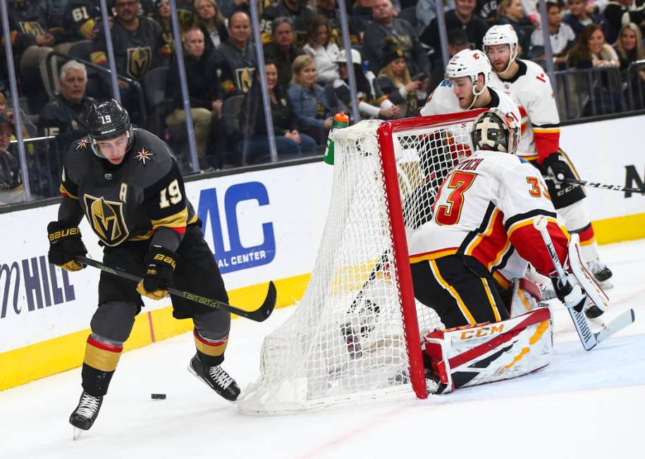 Golden Knights right wing Reilly Smith (19) skates around the net with the puck as Calgary Flames goaltender David Rittich (33) defends during the first period of an NHL hockey game at T-Mobile Ar ...