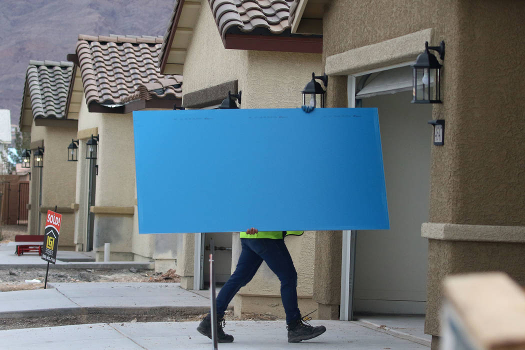 A Construction worker delivers a mirror during the new construction of LGI Homes at the Intersection of E. Lake Mead Boulevard and Dolly Lane photographed on Friday, March. 8, 2019, in Las Vegas. ...