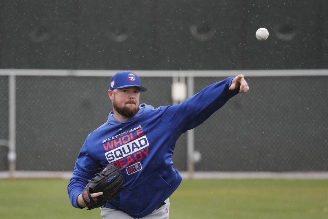 Chicago Cubs' Jon Lester throws in the rain during a spring training baseball workout Monday, Feb. 18, 2019, in Mesa, Ariz. (AP Photo/Morry Gash)