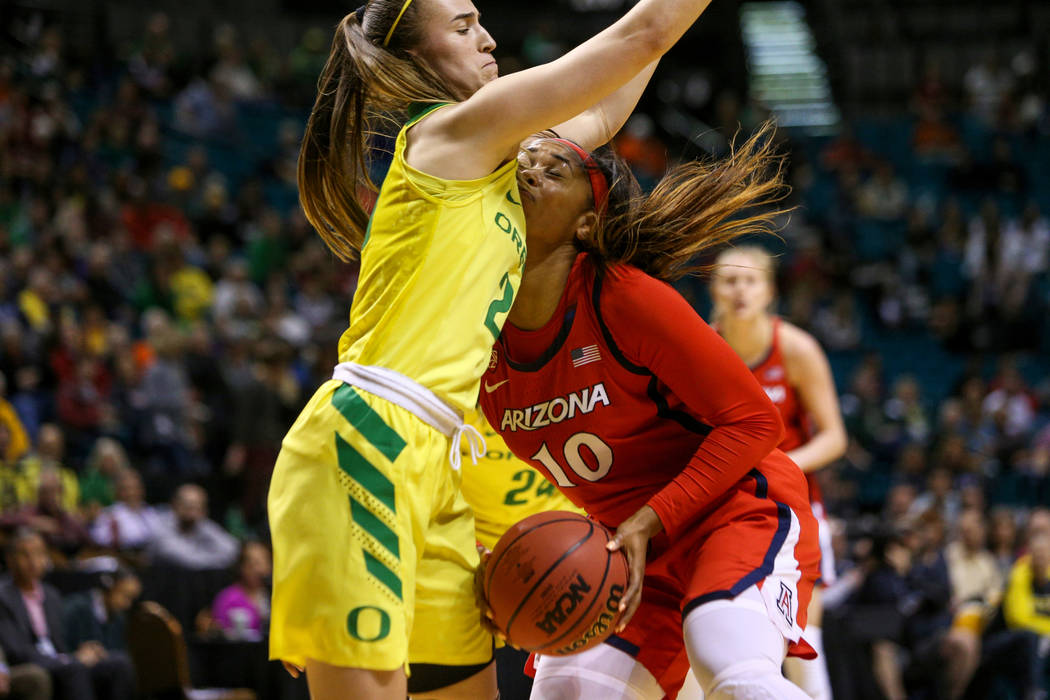 Arizona Wildcats forward Tee Tee Starks (10) falls into Oregon Ducks guard Sabrina Ionescu (20) during the first half of an NCAA college basketball game at the Pac-12 women's tournament at the MGM ...