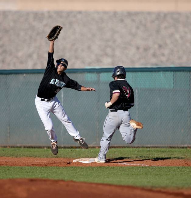 Faith Lutheran Dylan Howell (20) crosses first base as Silverado first baseman Jarod Hill (30) pulls in a high throw during a baseball game at Silverado High School in Las Vegas Friday, March 8, 2 ...