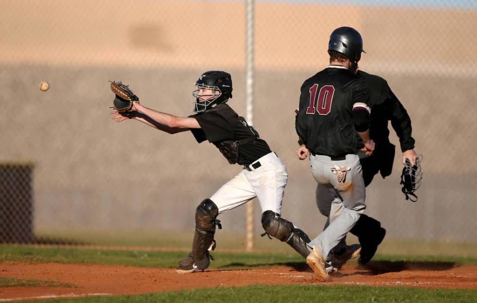 Faith Lutheran Michael Carroll (10) crosses home as Silverado catcher Seton Cifelli (21) fields the throw during a baseball game at Silverado High School in Las Vegas Friday, March 8, 2019. (K.M. ...