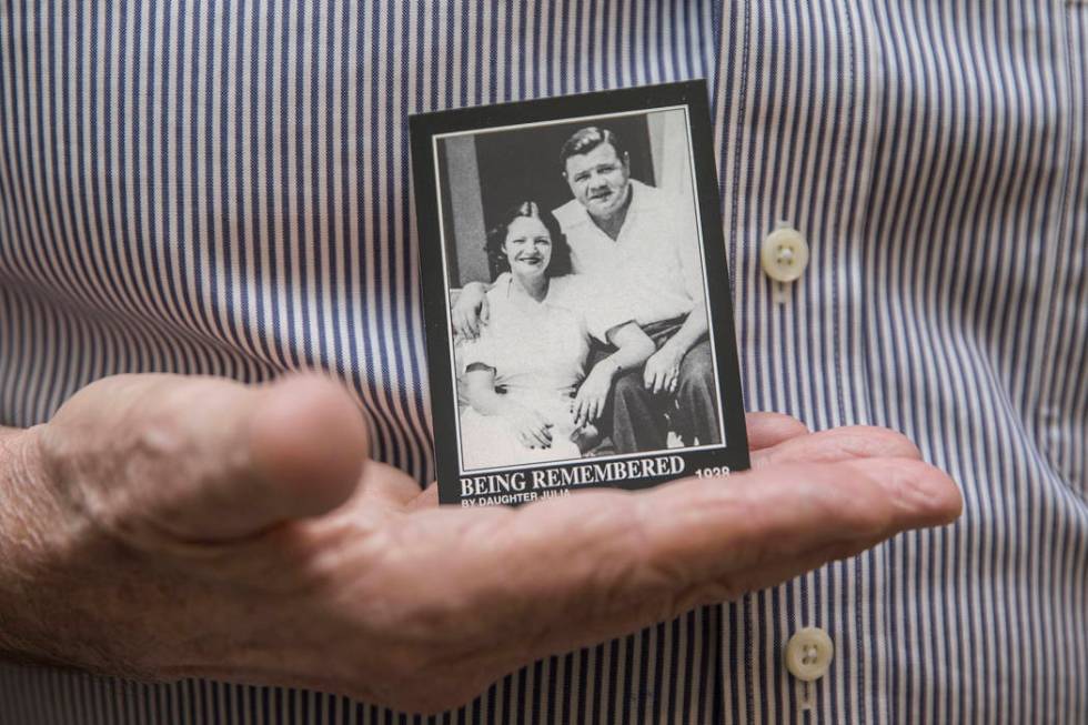Tom Stevens, the grandson of Babe Ruth, holds a commemorative card showing his mother Julia Ruth Stevens, left, with her father Babe Ruth, on Thursday, Jan. 31, 2019, at Stevens' home, in the Las ...