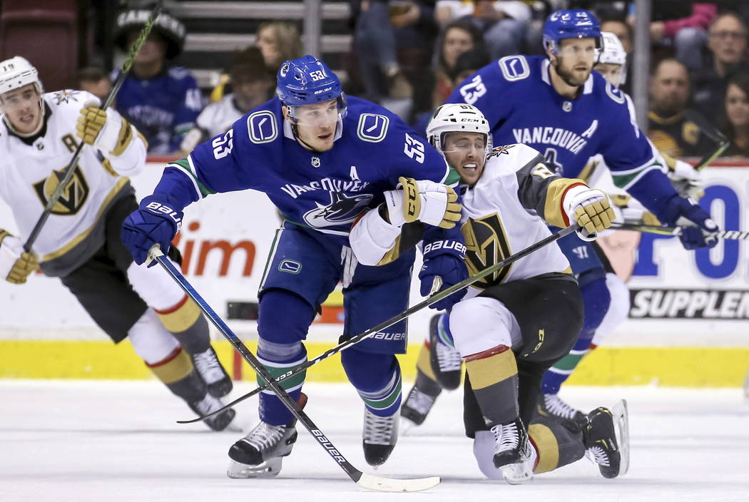 Vegas Golden Knights' Jonathan Marchessault (81) fights for the puck with Vancouver Canucks' Bo Horvat (53) during the first period of an NHL hockey game in Vancouver, British Columbia, Saturday, ...