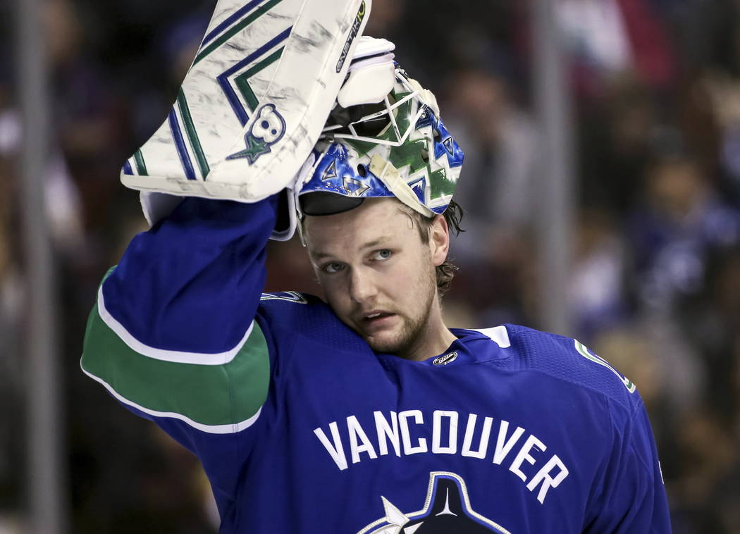 Vancouver Canucks goaltender Thatcher Demko (35) adjusts his mask during the second period of an NHL hockey game against the Vegas Golden Knights in Vancouver, British Columbia, Saturday, March 9, ...