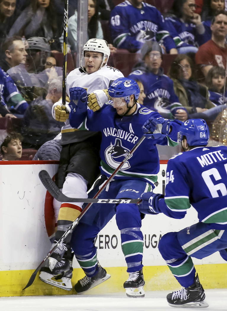 Vegas Golden Knights' Brayden McNabb (3) is checked by Vancouver Canucks' Jay Beagle (83) during the second period of an NHL hockey game in Vancouver, British Columbia, Saturday, March 9, 2019. (B ...