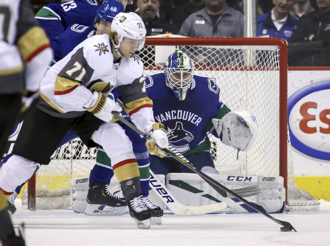 Vegas Golden Knights' William Karlsson (71) skates with the puck near Vancouver Canucks goaltender Jacob Markstrom (25) during the first period of an NHL hockey game in Vancouver, British Columbia ...