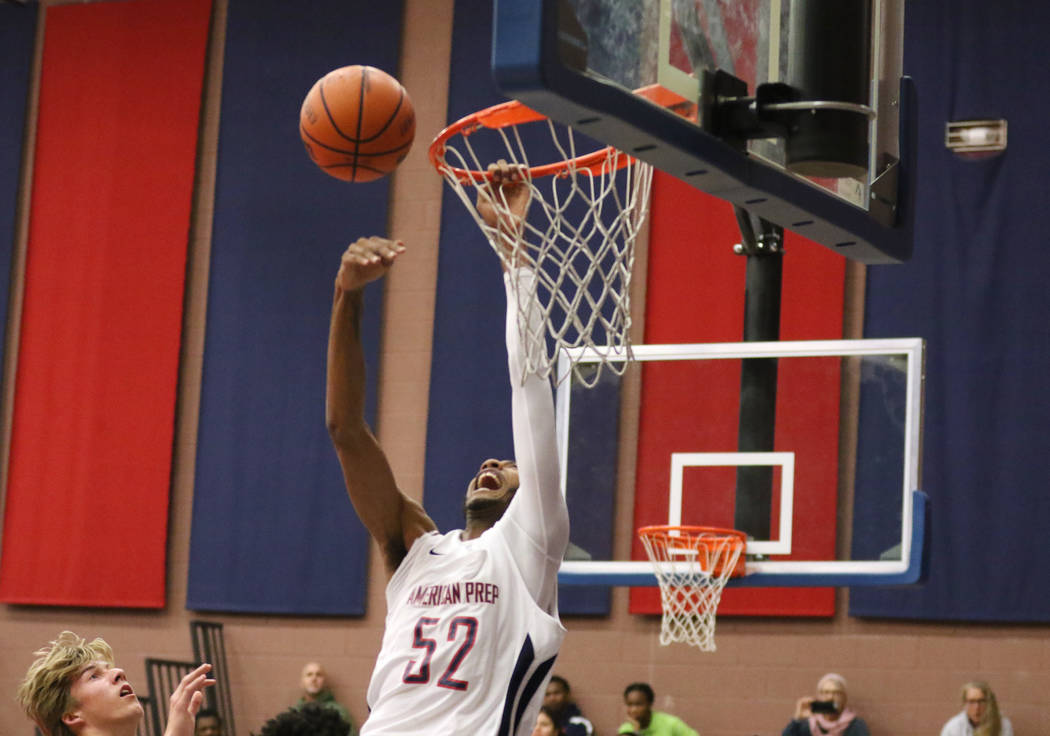 Darren Jones (52) grabs the rim as he tries to dunk the basketball during a game against SLAM Academy at American Preparatory Academy in Las Vegas, Thursday, Jan. 17, 2019. (Heidi Fang /Las Vegas ...