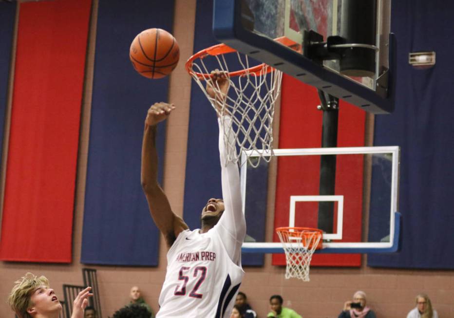 Darren Jones (52) grabs the rim as he tries to dunk the basketball during a game against SLAM Academy at American Preparatory Academy in Las Vegas, Thursday, Jan. 17, 2019. (Heidi Fang /Las Vegas ...