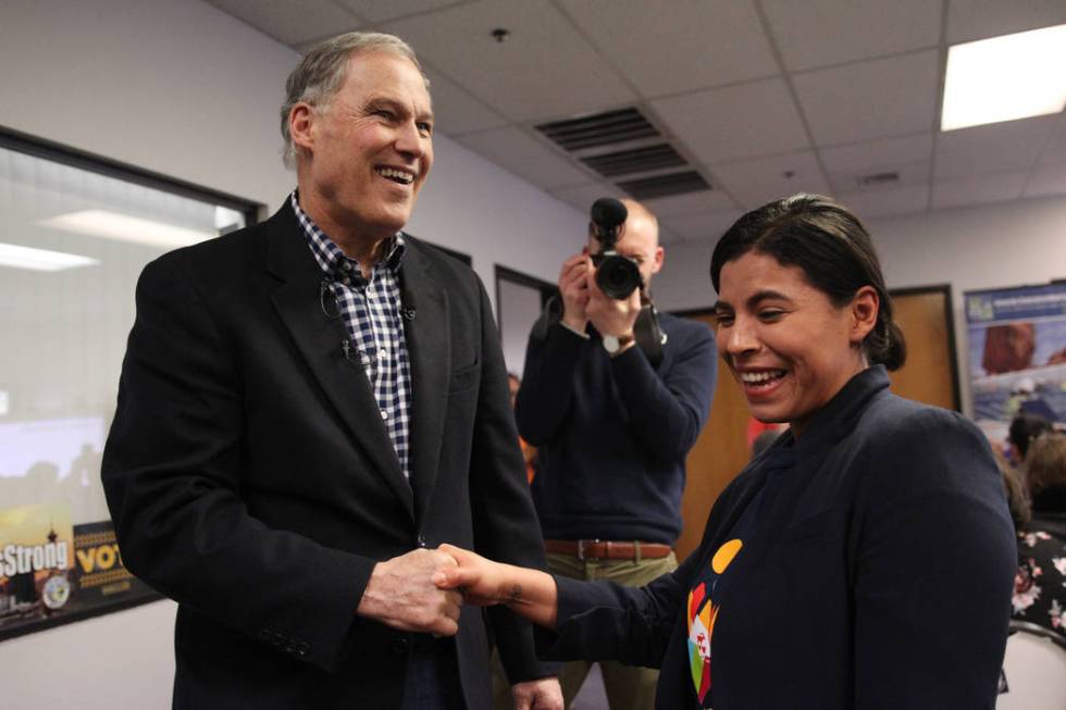 Washington Gov. Jay Inslee, left, a Democratic presidential candidate, shakes hands with Blanca Ortiz, organizer for the Nevada Conservation League, after speaking on climate change at the Nevada ...