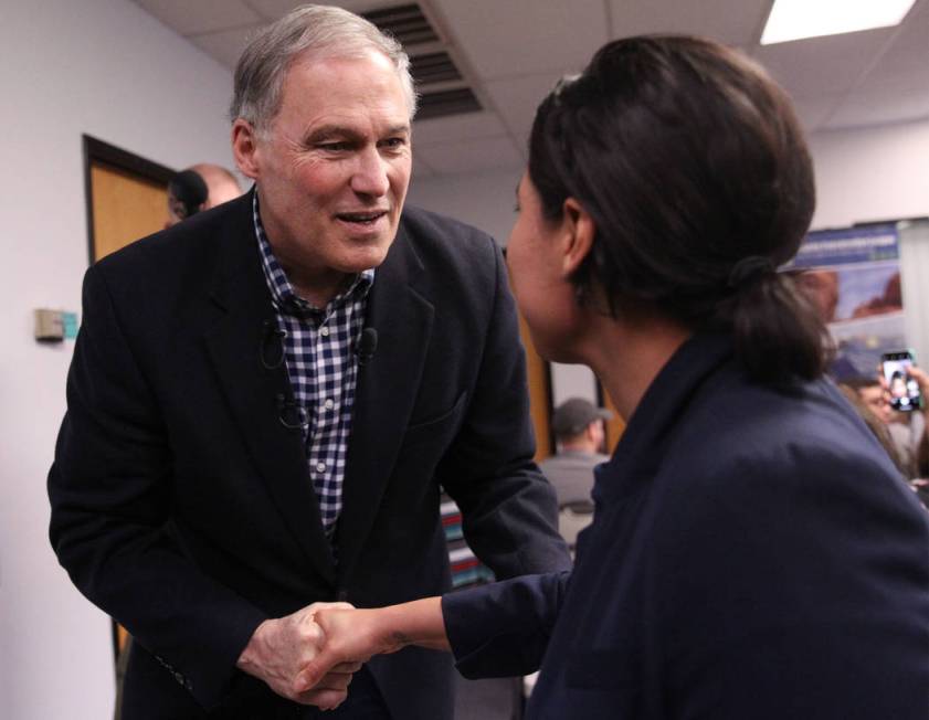 Washington Gov. Jay Inslee, left, a Democratic presidential candidate, shakes hands with Blanca Ortiz, organizer for the Nevada Conservation League, after speaking on climate change at the Nevada ...