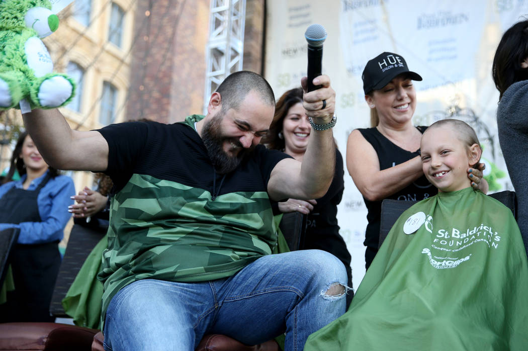 Dylan Foote, 8, of Las Vegas gets his head shaved by Jessica Buchmiller of Hue Salon in Las Vegas during St. Baldrick's Foundation shave-a-thon on the Brooklyn Bridge at New York-New York in Las V ...