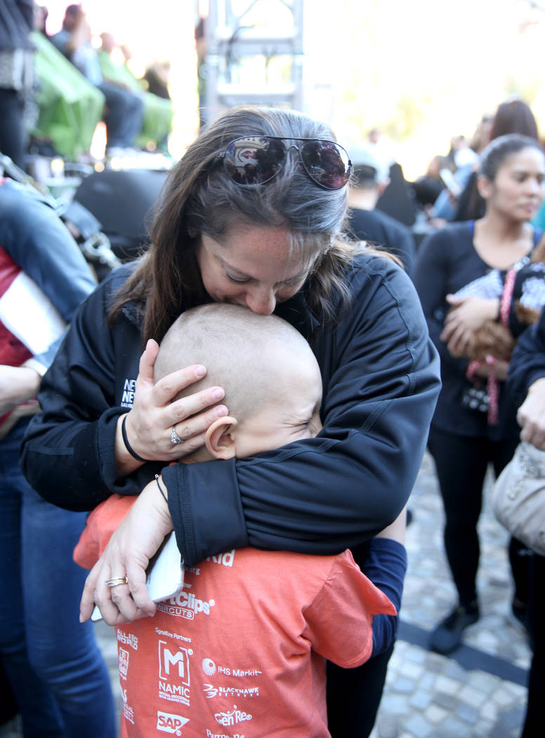 Dylan Foote, 8, of Las Vegas gets a hug from his mother Melanie after getting his head shaved during St. Baldrick's Foundation shave-a-thon on the Brooklyn Bridge at New York-New York in Las Vegas ...
