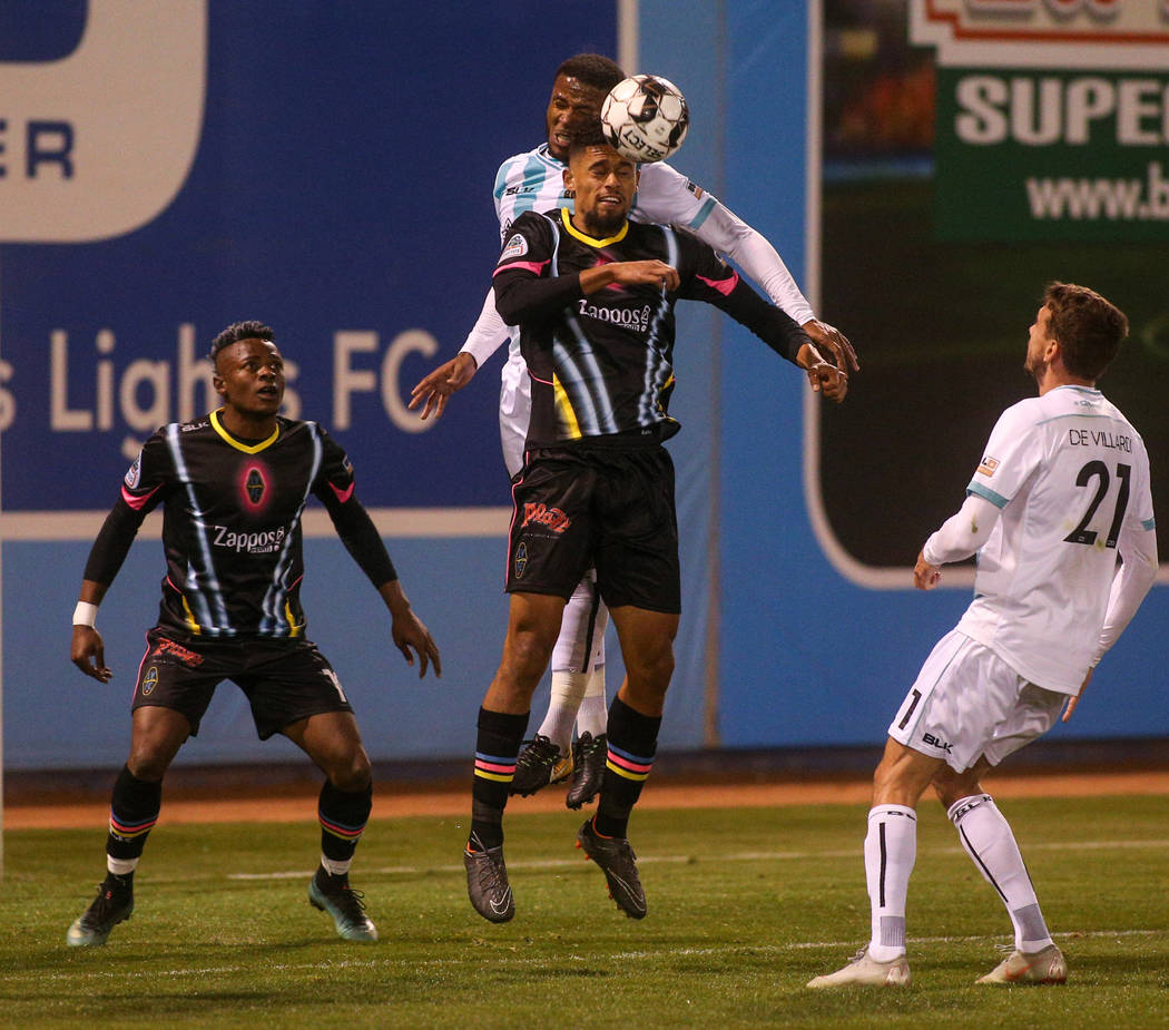 Las Vegas Lights FC defender Javan Torre (5) and Austin Bold FC defender Jermaine Taylor (4) both jump up to head the ball during the second half of a United Soccer League match at Cashman Field i ...