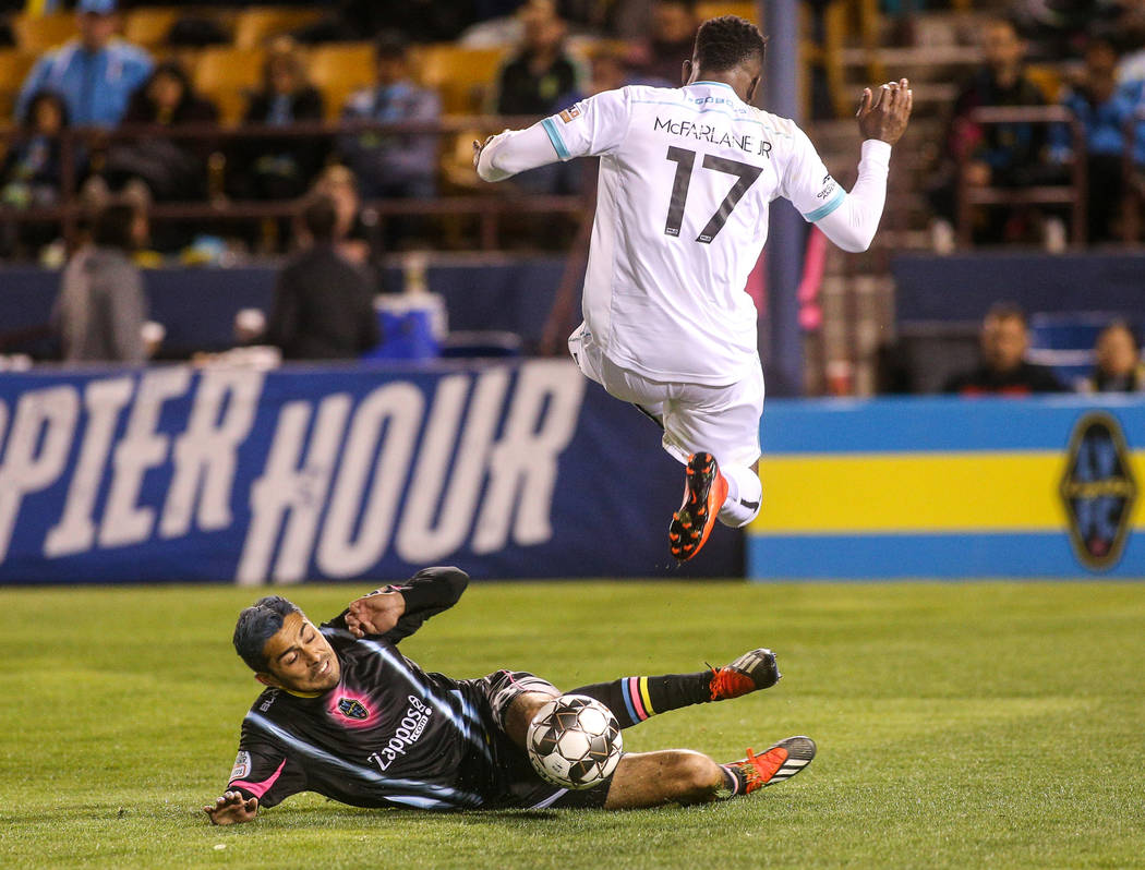 Las Vegas Lights FC midfielder Eric Gonzalez (28) slides to get the ball from Austin Bold FC defender Sean McFarlane (17) during the second half of a United Soccer League match at Cashman Field in ...