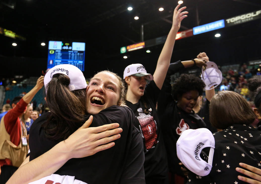 Stanford Cardinal forward Estella Moschkau (20) hugs a teammate while celebrating after defeating the Oregon Ducks during a NCAA college basketball game in the final of the Pac-12 women's tourname ...