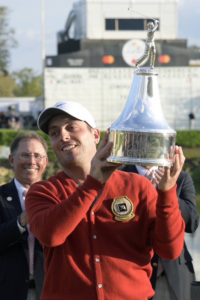 Francesco Molinari, of Italy, lifts the championship trophy after winning the Arnold Palmer Invitational golf tournament Sunday, March 10, 2019, in Orlando, Fla. (AP Photo/Phelan M. Ebenhack)