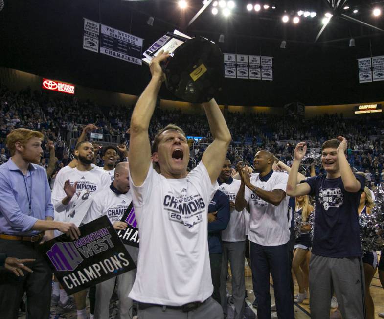 Nevada head coach Eric Musselman holds up the Mountain West Championship trophy after his team's win over San Diego State in an NCAA college basketball game in Reno, Nev., Saturday, March 9, 2019. ...