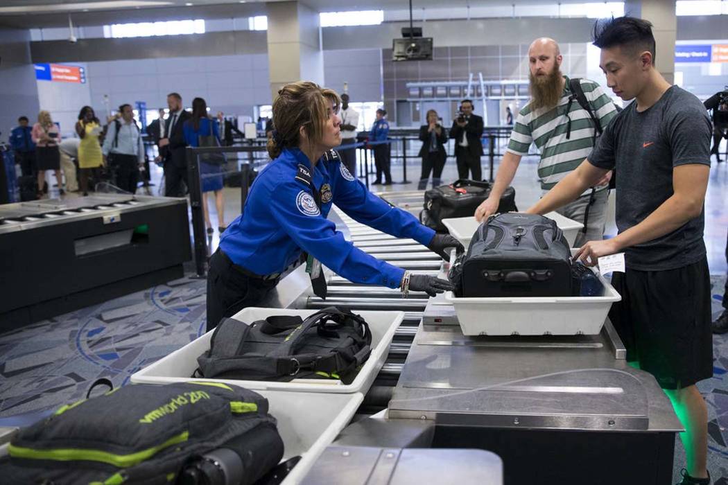 Transportation Security Administration agent Donna Franco, left, assists a passenger in one of the new automated screening lanes at McCarran International Airport Terminal 1 in Las Vegas, Aug. 31, ...