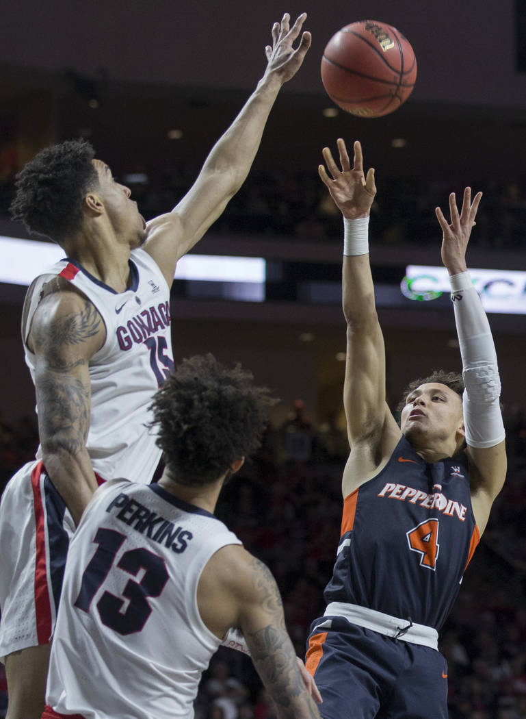 Pepperdine sophomore guard Colbey Ross (4) shoots a jump shot over Gonzaga junior forward Brandon Clarke (15) and senior guard Josh Perkins (13) in the second half during the West Coast Conference ...