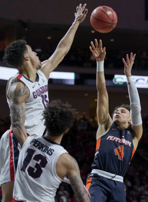 Pepperdine sophomore guard Colbey Ross (4) shoots a jump shot over Gonzaga junior forward Brandon Clarke (15) and senior guard Josh Perkins (13) in the second half during the West Coast Conference ...