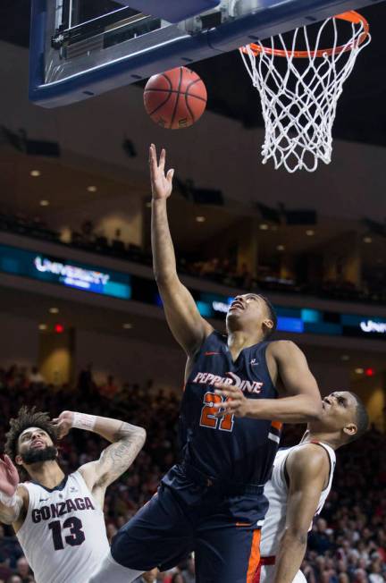 Pepperdine senior guard Eric Cooper Jr. (21) slices to the rim past Gonzaga senior guard Josh Perkins (13) in the second half during the West Coast Conference semifinal game on Monday, March 11, 2 ...