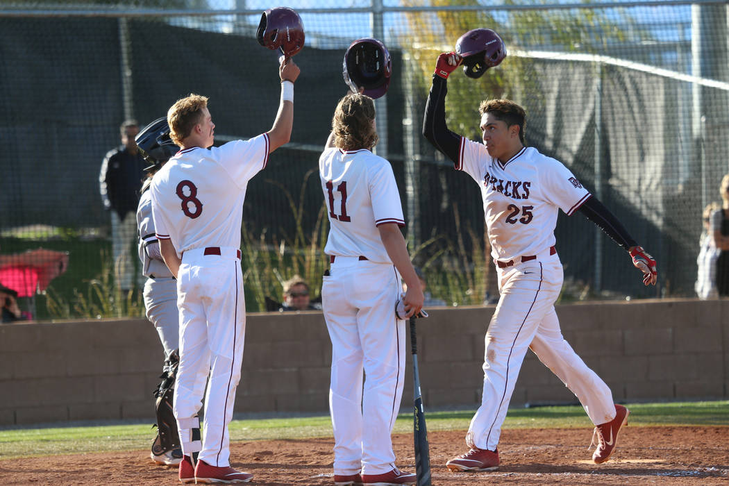 Desert Oasis' Aaron Roberts (25) scores a run with a homerun and celebrates with teammates Josh Sharman (11) and Zac Czerniawski (8) in the baseball game against Palo Verde at Desert Oasis High Sc ...