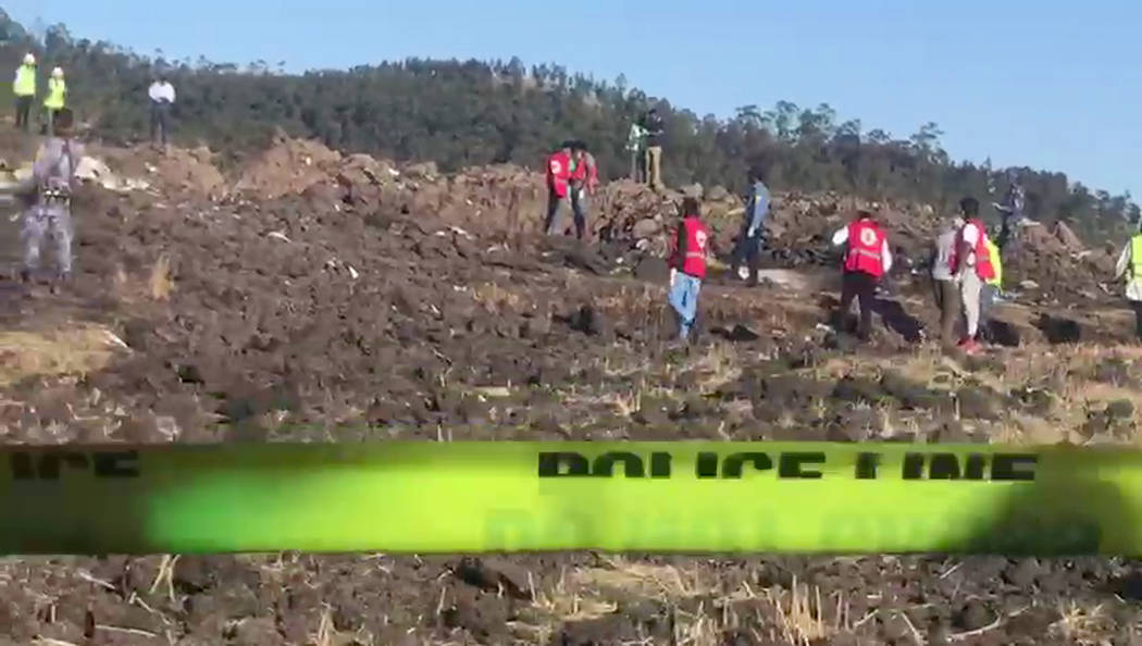 In this image taken from video, rescuers search through wreckage at the scene of an Ethiopian Airlines flight that crashed shortly after takeoff at Hejere near Bishoftu, or Debre Zeit, some 50 kil ...