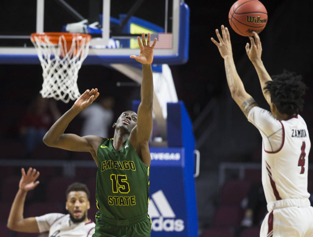 Chicago State sophomore center Noah Bigirumwami (15) reaches to block the shot of New Mexico State senior guard JoJo Zamora (4) in the second half of the opening round of the Western Athletic Conf ...