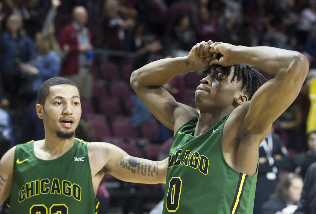 Chicago State senior forward Ken Odiase (0) is comforted by teammate Michael Johnson (22) after the Cougars lost to New Mexico State 86-49 in the opening round of the Western Athletic Conference t ...