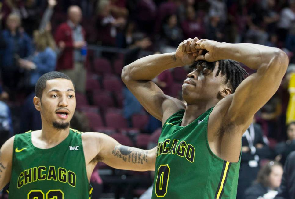 Chicago State senior forward Ken Odiase (0) is comforted by teammate Michael Johnson (22) after the Cougars lost to New Mexico State 86-49 in the opening round of the Western Athletic Conference t ...