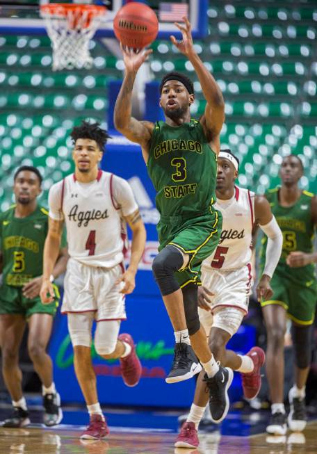 Chicago State sophomore guard Travon Bell (3) sprints up court past New Mexico State senior guard JoJo Zamora (4) and guard Clayton Henry (5) to try and beat the clock at the end of the first half ...