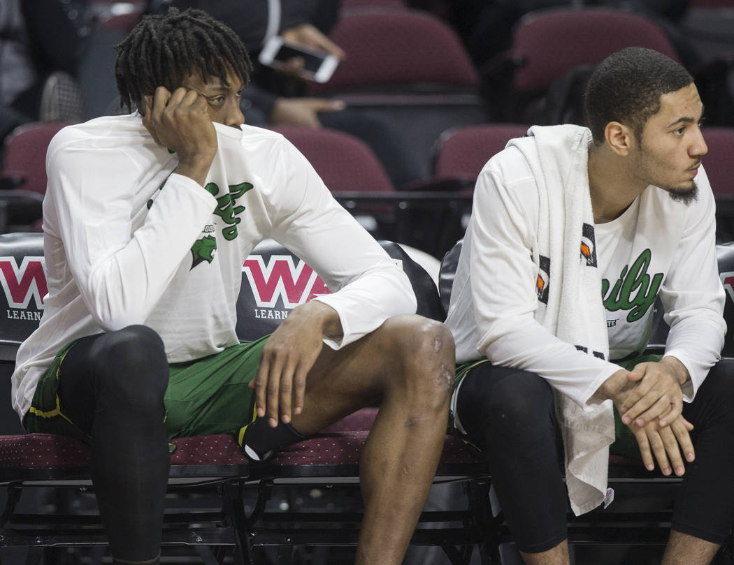 Chicago State senior forward Ken Odiase, left, sits dejected on the bench as time winds down on a 86-49 loss to New Mexico State in the opening round of the Western Athletic Conference tournament ...