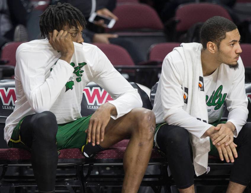 Chicago State senior forward Ken Odiase, left, sits dejected on the bench as time winds down on a 86-49 loss to New Mexico State in the opening round of the Western Athletic Conference tournament ...