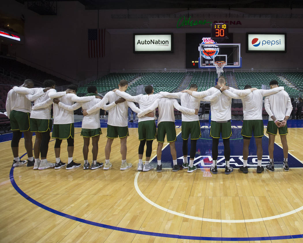 Chicago State locks arms as the national anthem plays before the start of the Cougars opening round Western Athletic Conference tournament game with New Mexico State on Thursday, March 14, 2019, a ...
